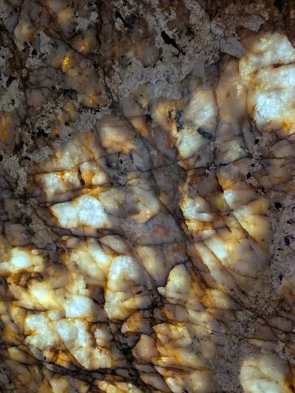 A translucent crystal panel lit from behind, its veining glowing amber and gold