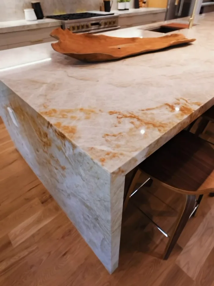 A waterfall kitchen island in gold-veined quartzite