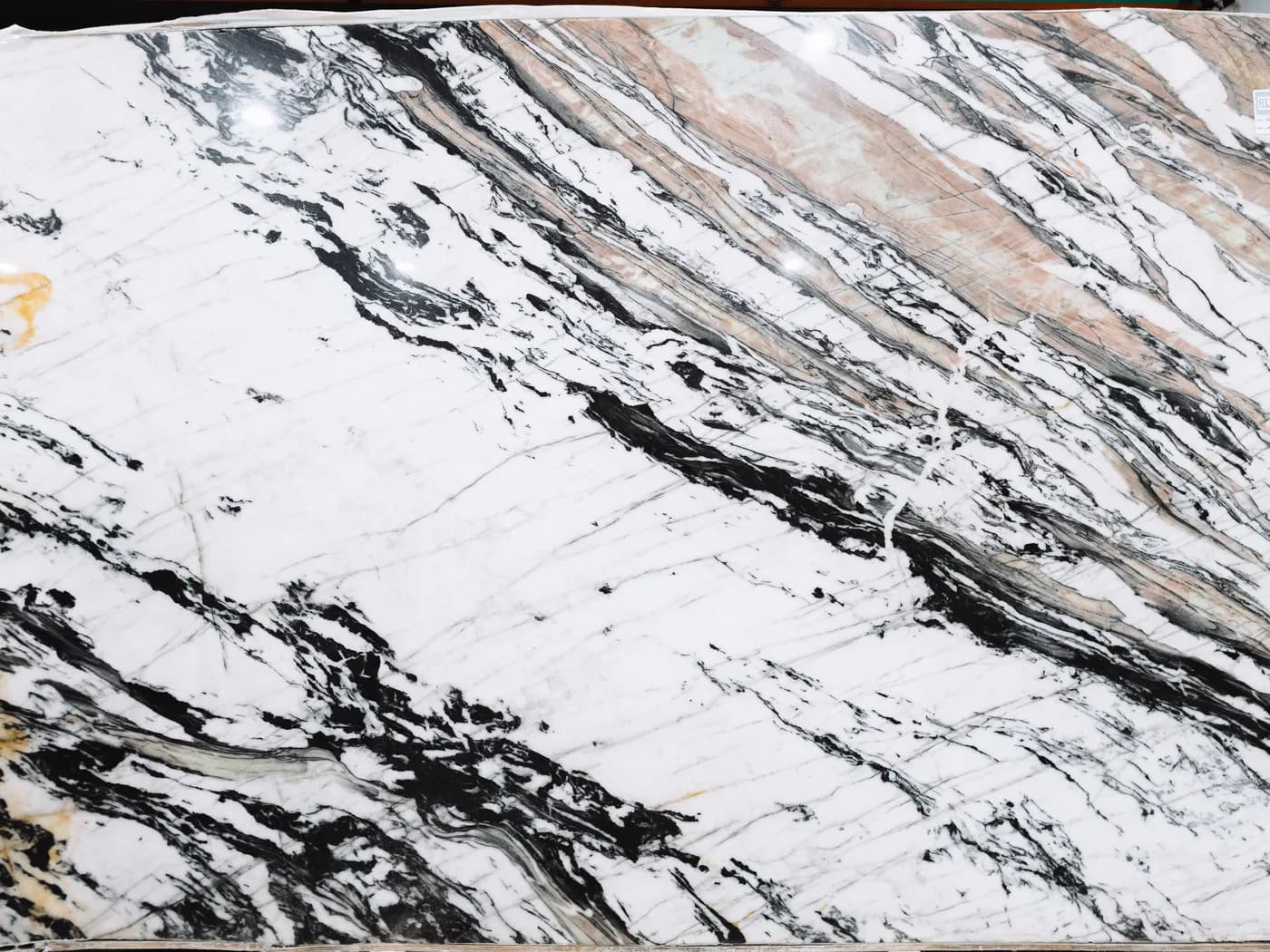 A white marble slab crossed by black and russet veining