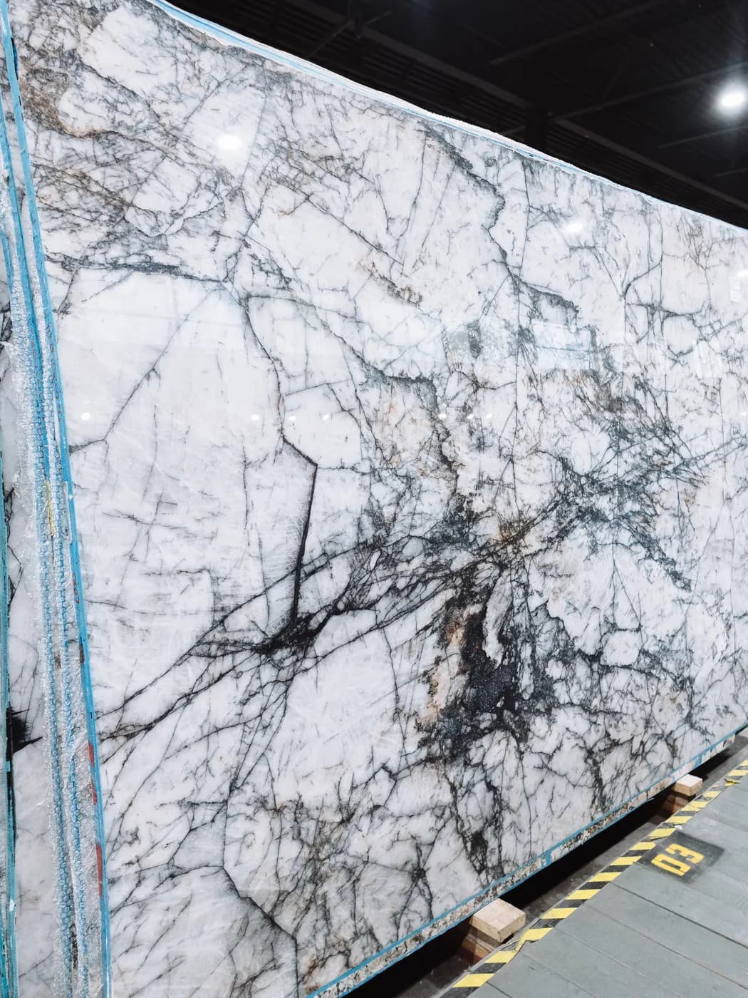 A white slab veined with violet and charcoal in a spiderweb pattern