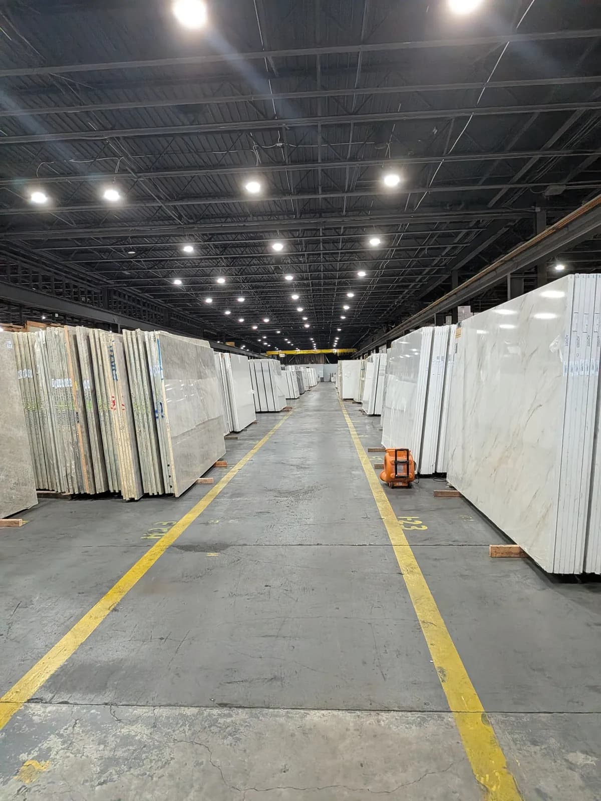 Wide aisles lined with white slabs, yellow lines on the floor